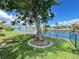 Lush green backyard features a mature tree and a fenced canal view, enhancing the outdoor living experience at 931 Juno Dr, Punta Gorda, FL 33950
