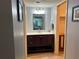Bathroom showcasing single vanity with unique mirror and linen closet access at 931 Juno Dr, Punta Gorda, FL 33950