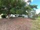 A light blue single-story home with a mature shade tree in front and vibrant flower bushes at 931 Juno Dr, Punta Gorda, FL 33950