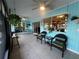 Enclosed lanai with blue accent wall, hanging plants, and dining table set with views of the home's yard at 931 Juno Dr, Punta Gorda, FL 33950