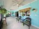 Enclosed lanai with bright blue walls, tile floors, ceiling fans, and waterfront views at 931 Juno Dr, Punta Gorda, FL 33950