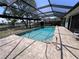 Enclosed pool area with brick-paved deck and canal view is perfect for outdoor entertaining at 931 Juno Dr, Punta Gorda, FL 33950