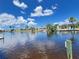 Waterfront view showing calm water, docks, and homes with lush landscaping under a blue sky at 931 Juno Dr, Punta Gorda, FL 33950