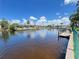 Beautiful waterfront view with private docks, lush landscaping, and peaceful canal waters under a blue sky at 931 Juno Dr, Punta Gorda, FL 33950