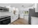 Beautiful kitchen with stainless steel appliances, white cabinetry, and modern fixtures at 1020 Drury Ln, Englewood, FL 34224