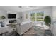 Inviting living room featuring a cozy fireplace, abundant natural light from large windows, and stylish neutral decor at 1020 Drury Ln, Englewood, FL 34224