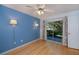 Light and airy bedroom with hardwood floors, bright blue accent wall, and access to an outdoor patio at 1051 Forrest Nelson Blvd # 104, Port Charlotte, FL 33952