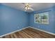 Cozy bedroom with wood-look floors, a ceiling fan, and a bright window to let in natural light at 1051 Forrest Nelson Blvd # 104, Port Charlotte, FL 33952