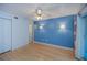 Bedroom featuring a blue accent wall, ceiling fan and a door leading to an outdoor balcony at 1051 Forrest Nelson Blvd # 104, Port Charlotte, FL 33952