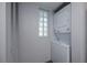 Functional laundry area featuring stacked washer and dryer, glass block window for natural light, and storage at 1051 Forrest Nelson Blvd # 104, Port Charlotte, FL 33952
