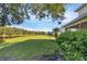 A view of a spacious backyard with green grass and pond views at 1085 Jonah Dr, North Port, FL 34289