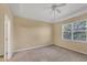 Bedroom with neutral carpet, ceiling fan, tray ceiling, and a window for natural light at 1085 Jonah Dr, North Port, FL 34289