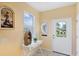 Bright foyer featuring a decorative table, a window with blinds, and a white front door at 1085 Jonah Dr, North Port, FL 34289