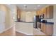 Open kitchen featuring breakfast bar, wood cabinets, and stainless steel appliances at 1085 Jonah Dr, North Port, FL 34289