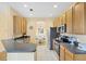 Well-equipped kitchen with wooden cabinets, granite counters, stainless steel appliances, and views to dining area at 1085 Jonah Dr, North Port, FL 34289