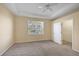 Main bedroom with neutral carpet, ceiling fan, tray ceiling, window, and walk-in closet at 1085 Jonah Dr, North Port, FL 34289