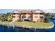 Waterfront condo building featuring a boat dock, a well-maintained lawn, and picturesque water views at 1326 Wesley Dr # 123, Punta Gorda, FL 33950