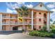 Exterior view of a condo building featuring a well-manicured landscape and a convenient drive-through at 1326 Wesley Dr # 123, Punta Gorda, FL 33950
