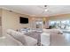 Open living room featuring plush sofas, ceiling fan, TV, and access to the balcony at 1326 Wesley Dr # 123, Punta Gorda, FL 33950