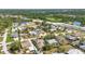 Aerial view of a suburban area showcasing homes, green spaces, and a road in a sunny, residential setting at 1357 Le Pera Rd, Englewood, FL 34223