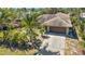Aerial shot of a home with a large driveway, a two-car garage, and mature landscaping at 1357 Le Pera Rd, Englewood, FL 34223
