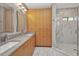 Modern bathroom with double sink, sleek vanity, and glass-enclosed shower at 1357 Le Pera Rd, Englewood, FL 34223