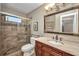 Elegant bathroom with a glass shower, marble counter tops, and a decorative mirror at 1357 Le Pera Rd, Englewood, FL 34223