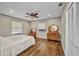 Bedroom with hardwood floors, neutral paint, bright windows, and ceiling fan at 1357 Le Pera Rd, Englewood, FL 34223
