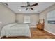 Bedroom with hardwood floors, neutral paint, bright windows, and ceiling fan at 1357 Le Pera Rd, Englewood, FL 34223