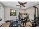 Bright exercise room featuring free weights, weight machines, a ceiling fan, and a decorative window at 1357 Le Pera Rd, Englewood, FL 34223
