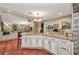 Open kitchen with terracotta tile floors, stainless appliances, granite countertops, and custom white cabinets at 1357 Le Pera Rd, Englewood, FL 34223