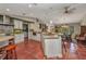 Open-concept kitchen featuring terracotta tile floors, white cabinets, granite countertops and stainless steel appliances at 1357 Le Pera Rd, Englewood, FL 34223