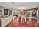 Open concept kitchen with terracotta tile flooring, custom white cabinets, granite countertops and stainless appliances at 1357 Le Pera Rd, Englewood, FL 34223