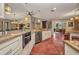 Open kitchen with granite countertops, stainless steel appliances, terracotta tile floors, and an island with seating at 1357 Le Pera Rd, Englewood, FL 34223