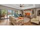 Bright living room featuring brick accent wall, built-ins, and sliding doors to the outdoor pool at 1357 Le Pera Rd, Englewood, FL 34223