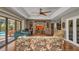 Living room with vaulted ceiling, brick accent wall, built-ins, and sliding doors to the pool at 1357 Le Pera Rd, Englewood, FL 34223