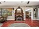 Living room with a decorative fireplace, terracotta flooring, and natural light at 1357 Le Pera Rd, Englewood, FL 34223