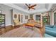 Spacious living room with hardwood floors, decorative ceiling fan and vintage furniture at 1357 Le Pera Rd, Englewood, FL 34223
