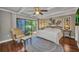Charming bedroom with garden view, wood floors, and white beamed ceilings at 1357 Le Pera Rd, Englewood, FL 34223