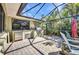 Outdoor kitchen in a screened-in patio, with a grill, sink, and stainless steel refrigerator at 1357 Le Pera Rd, Englewood, FL 34223