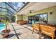 Outdoor patio featuring a seating area, dining table, ceiling fans, and pool access at 1357 Le Pera Rd, Englewood, FL 34223