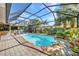 Landscaped backyard featuring an enclosed pool, brick patio, and a relaxing lounge area at 1357 Le Pera Rd, Englewood, FL 34223