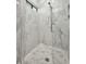 Close up of marble walled glass shower featuring tiled floors at 1357 Le Pera Rd, Englewood, FL 34223
