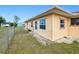 Exterior corner view showing large side yard, windows, door, and chain link fence at 167 N Cambridge Nw Dr, Port Charlotte, FL 33952