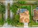 Aerial view of a home with a screened in pool, landscaped yard, and mature trees at 1814 Pinyon Pine Dr, Sarasota, FL 34240