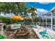 Outdoor entertaining space including a fire pit, bar, seating, and screened lanai at 1814 Pinyon Pine Dr, Sarasota, FL 34240