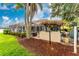 A well-maintained backyard with green grass, a covered patio area, and a tiki bar at 1814 Pinyon Pine Dr, Sarasota, FL 34240