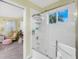 Bright bathroom with a shower and view of a cozy sitting area through an open doorway at 1814 Pinyon Pine Dr, Sarasota, FL 34240