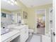 Bright bathroom with white cabinets, double sinks, and an adjacent bedroom view at 1814 Pinyon Pine Dr, Sarasota, FL 34240