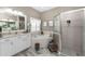Bathroom with dual sink vanity, soaking tub, and glass-enclosed shower at 1814 Pinyon Pine Dr, Sarasota, FL 34240